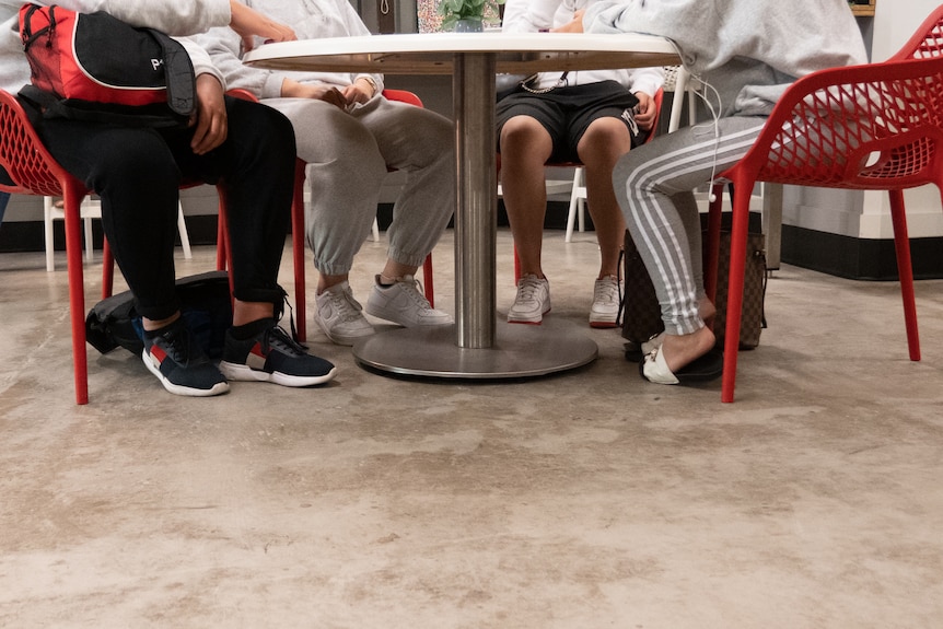 A group of young people sit around a table at the Night Cafe.