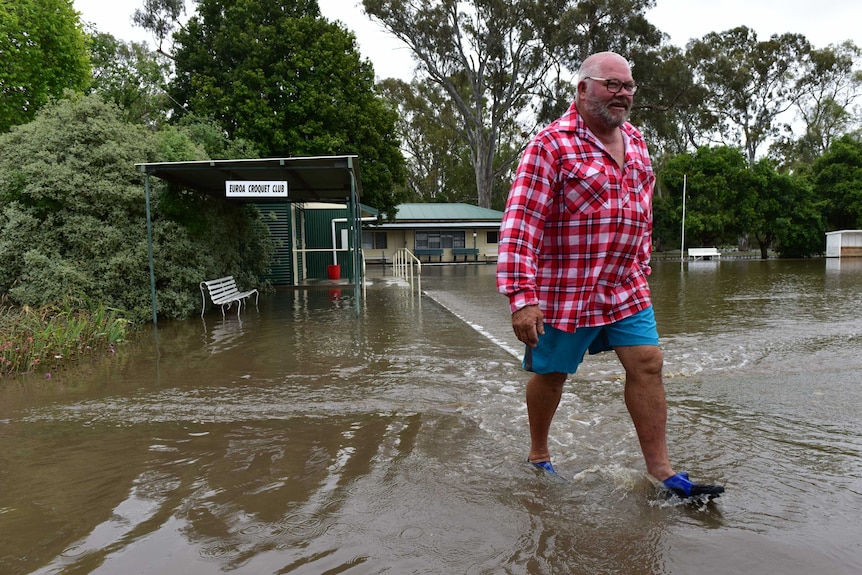 A local resident walks through floodwater in Euroa, Victoria.