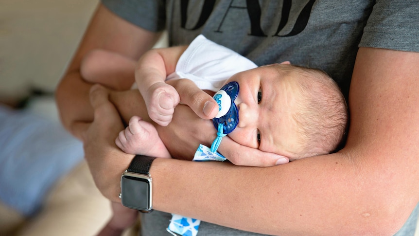 Close up of dad holding newborn baby