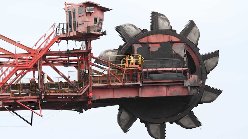 Grey clouds loom above ship-loading machinery in operation at the Port Kembla Coal Terminal in New South Wales.