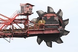 Grey clouds loom above ship-loading machinery in operation at the Port Kembla Coal Terminal in New South Wales.