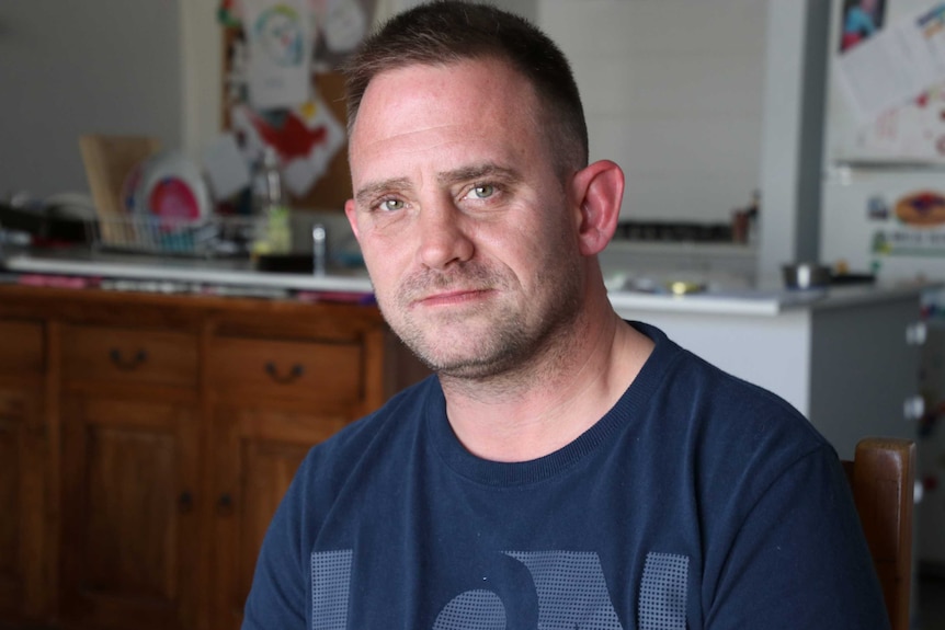 A head and shoulders shot of Adam Hughes sitting in his kitchen.