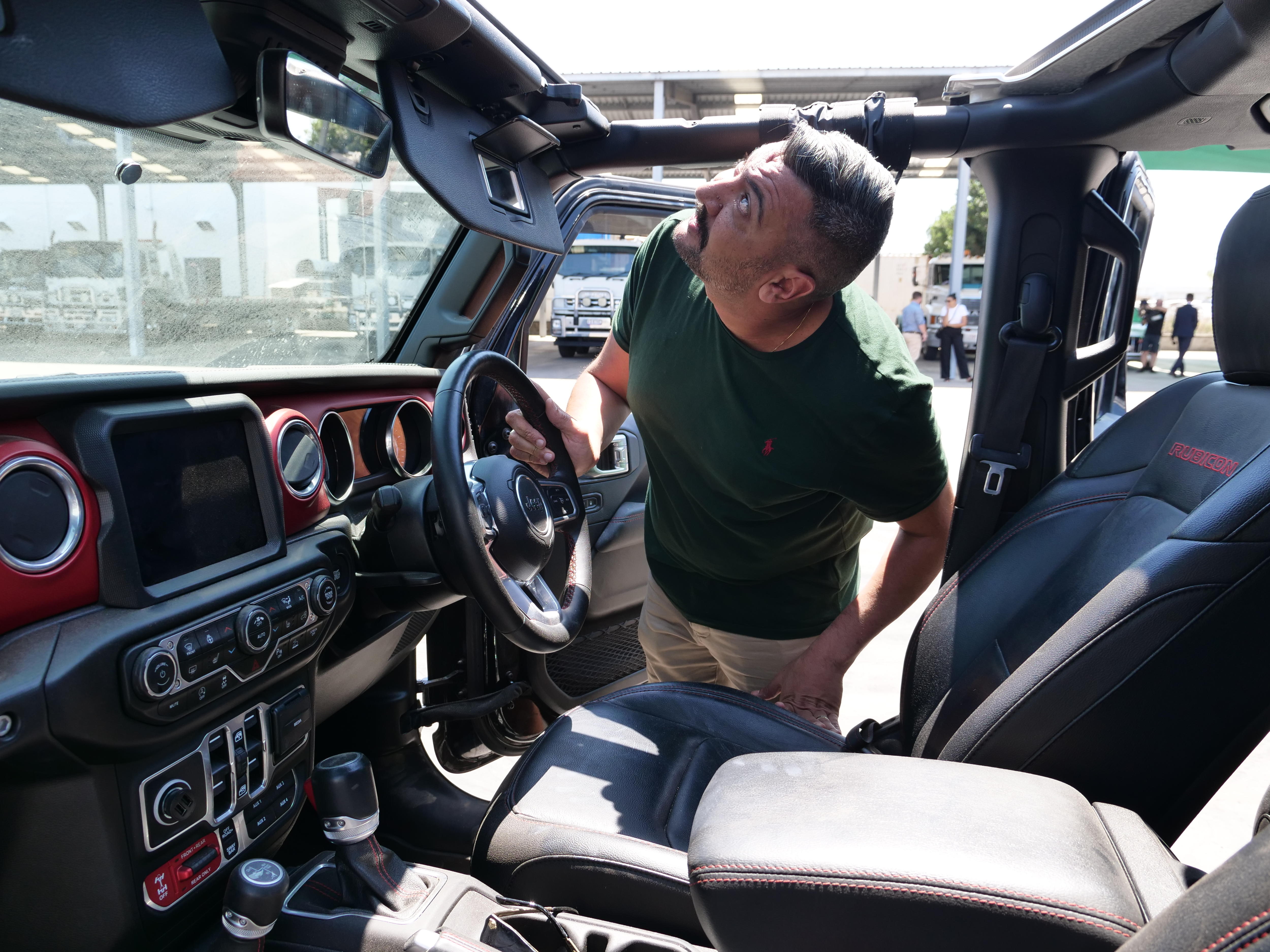 A man looks inside a car.