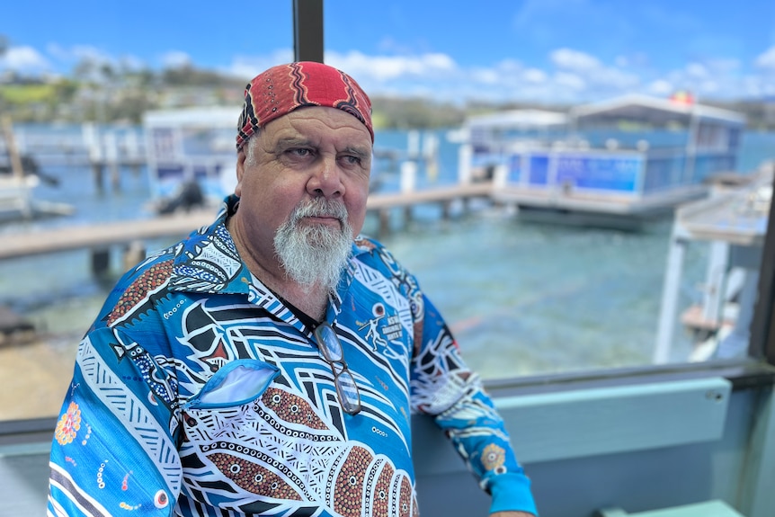 Man in blue shirt wearing a red bandana 