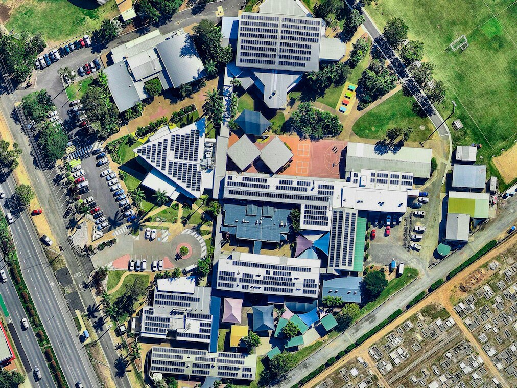 an aerial of a school with solar panels