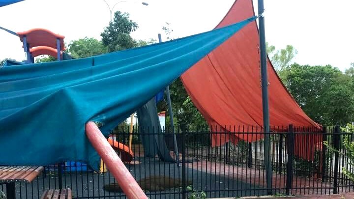 A metal pole is uprooted, smashing into a playground fence and shade sales.