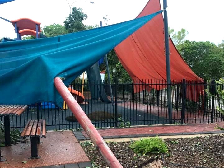 A metal pole is uprooted, smashing into a playground fence and shade sales.