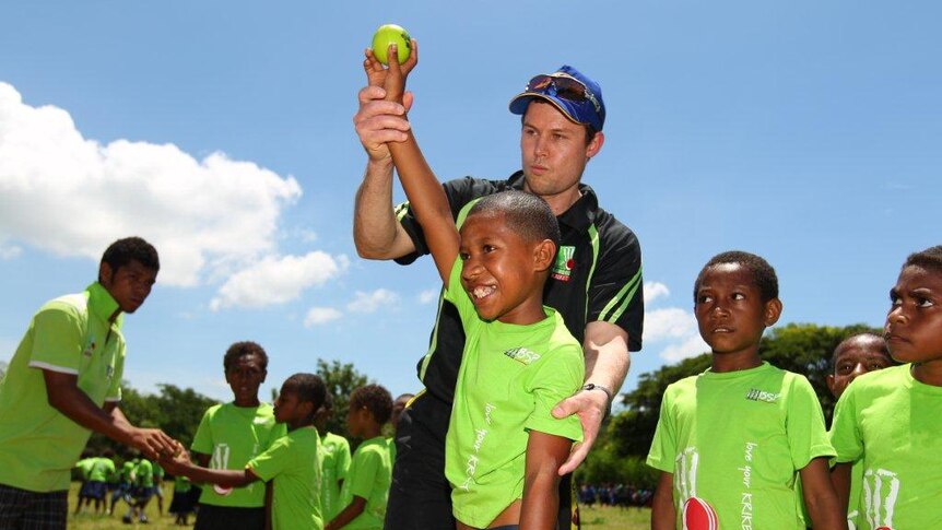 A boy is taught correct bowling technique during training.