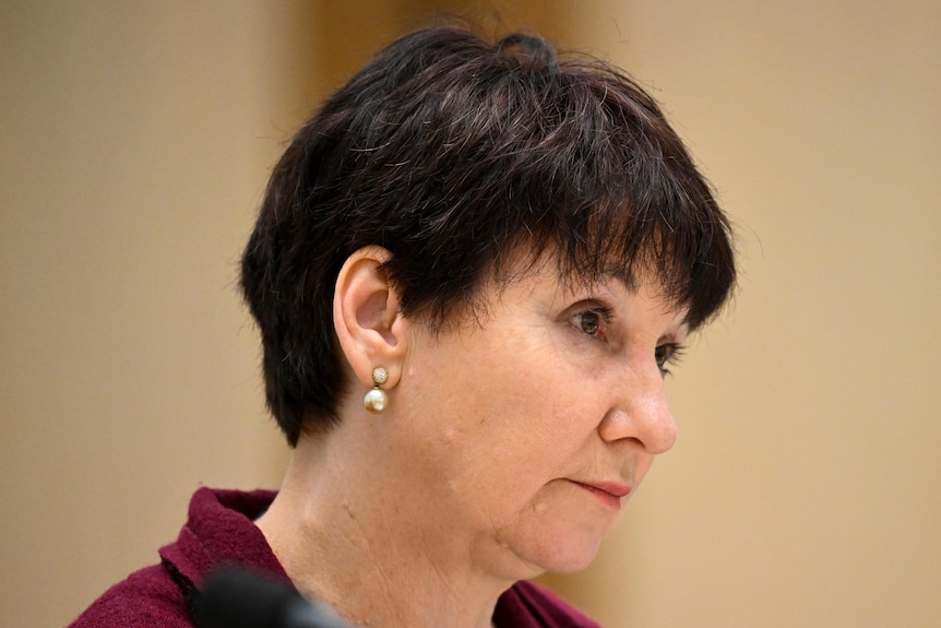 A woman with short hair looks pensive