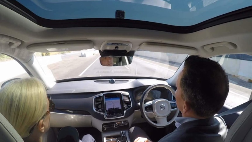 Two people sit inside the driverless car on the South Expressway in Adelaide.