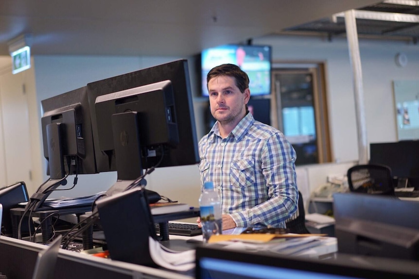 Matt Liddy sitting at desk looking at computer.