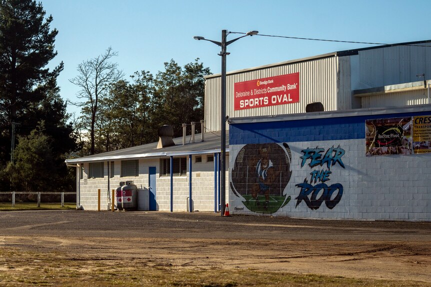 A mural that says "Fear the Roo" is painted onto the side of a white football club building with blue accents.