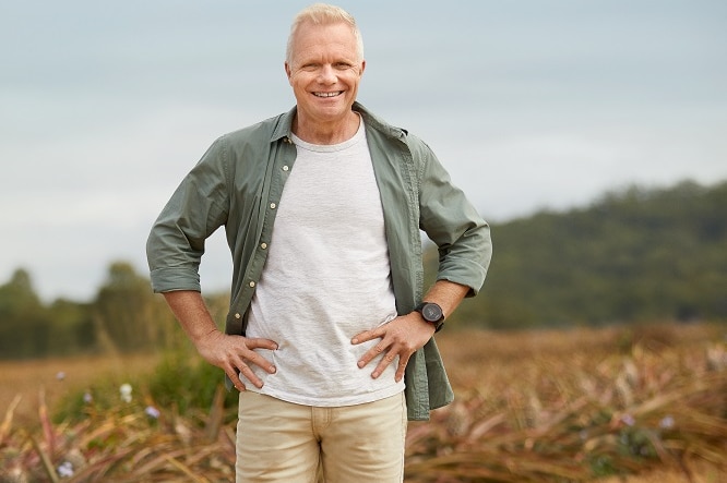 Paul Turner from Woolworths stands in front of a field of pineapples in Queensland