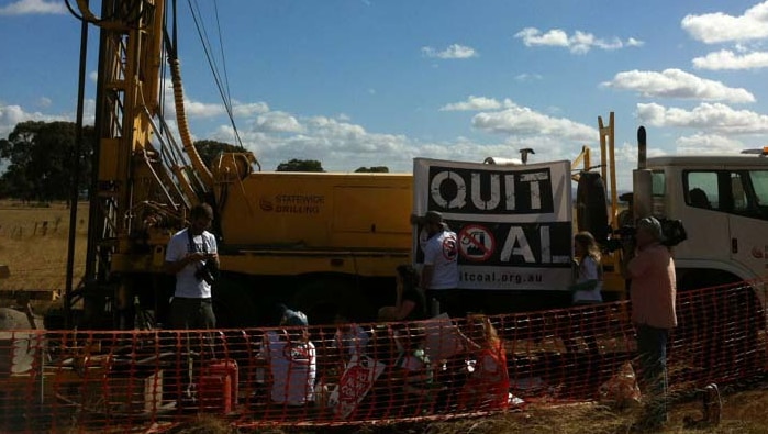 Two protesters, including a pregnant woman, have chained themselves to a coal drilling rig.