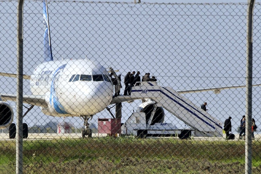 Passengers evacuate a hijacked EgyptAir Airbus 320 plane at Larnaca airport, Cyprus.