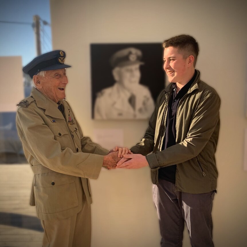 Brian Winspear in military uniform and teenager Mack Brown in front of Brian's portrait