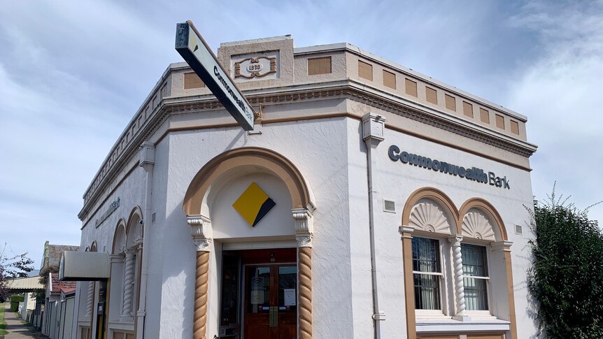Image of a Commonwealth Bank branch, a historic building, which sits on the corner of a street, with a white fascade