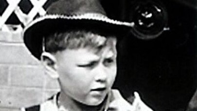Balck and white archival photo: Young boy in cowboy hat dress-up