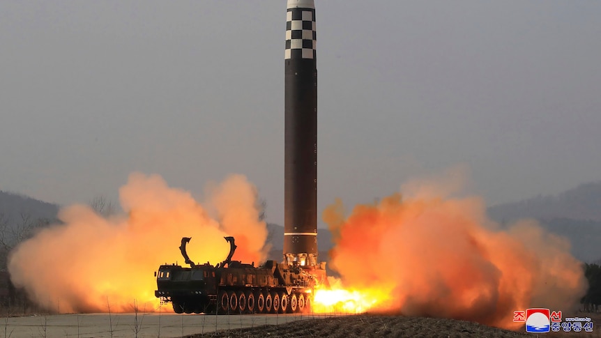一枚大型洲际弹道导弹从一辆卡车上垂直发射，其排气产生的火焰击中地面。” class=