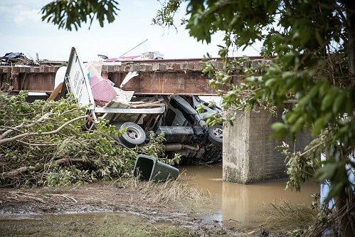 A crushed truck swept by flood waters into a railway bridge in South Murwillumbah.