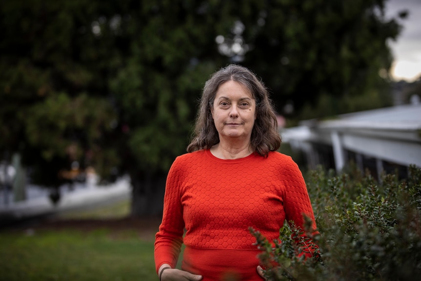 A woman stands in a garden.