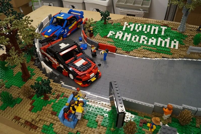 Cars made of lego driving around a lego track with the words Mount Panorama in lego.