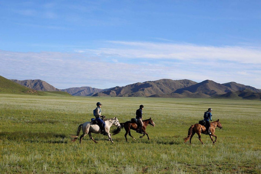 Three people on horseback.