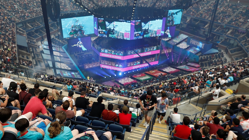 Thousands of fans in Arthur Ashe stadium watch Fortnite on big screens.