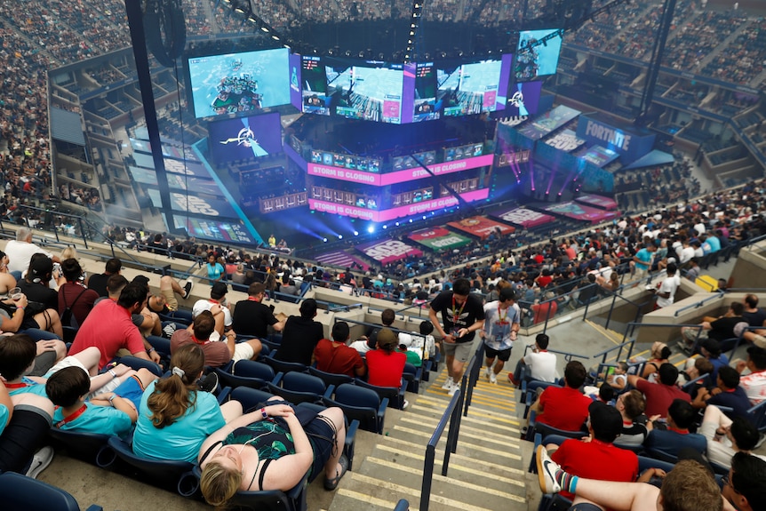 Thousands of fans in Arthur Ashe stadium watch Fortnite on big screens.