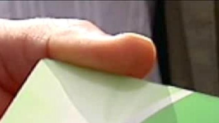 Hand holding a BasicsCard (ABC TV News)