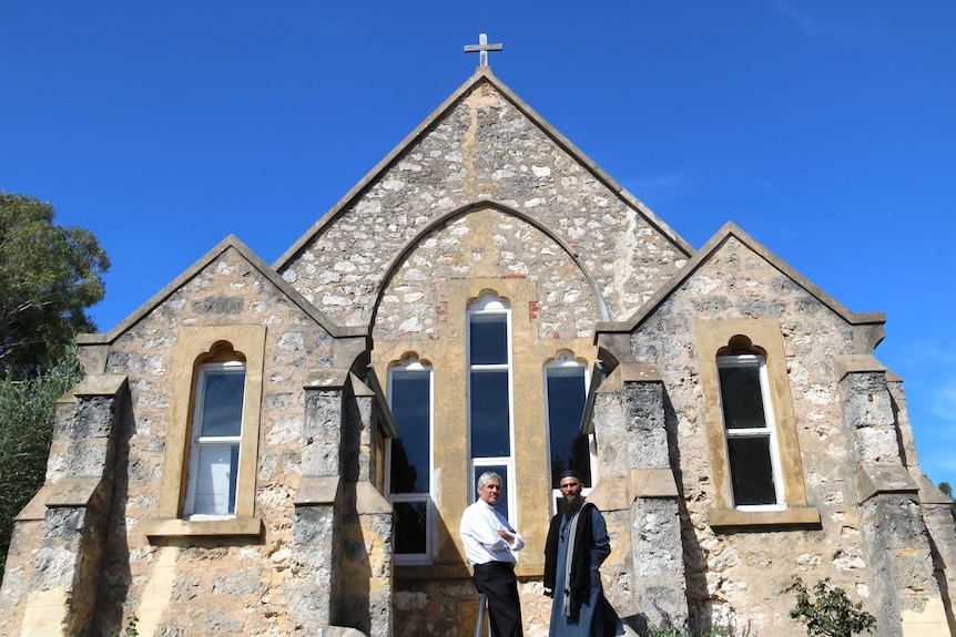 Two religious leaders outside a church