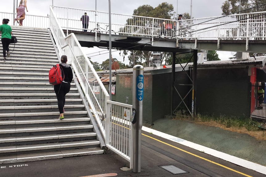 A Sydney train station with a ramp to get over the railway station but steps to and from the platform