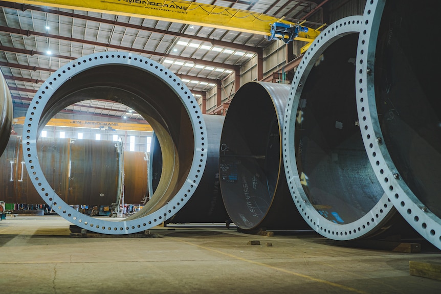 Large cylinder pieces sitting in a warehouse.