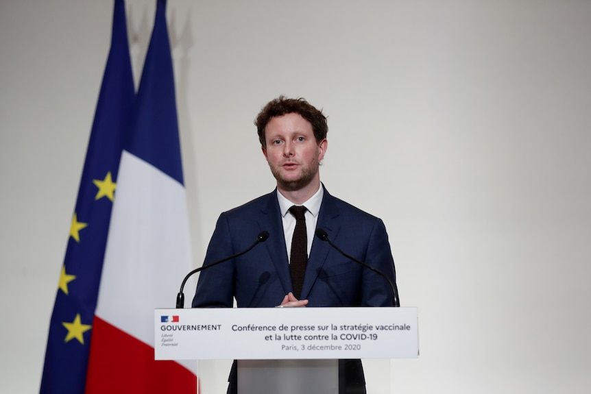 A man stands behind a lectern 