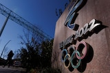 A sign on a wall reads 'Beijing 2022' with multicoloured olympic rings below 