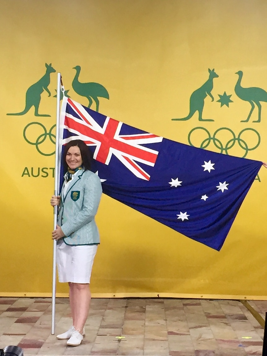 Anna Meares stands with the Australian flag after being announced as flagbearer