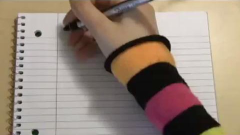 Hand holds pen ready to write in exercise book