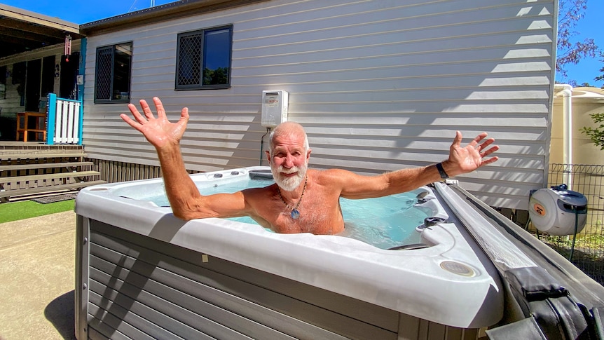 A man sitting in a spa looking very happy.