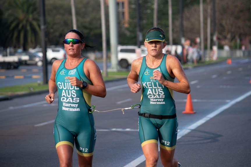 Katie Kelly and her guide Briarna Silk run during a Para-triathlon.