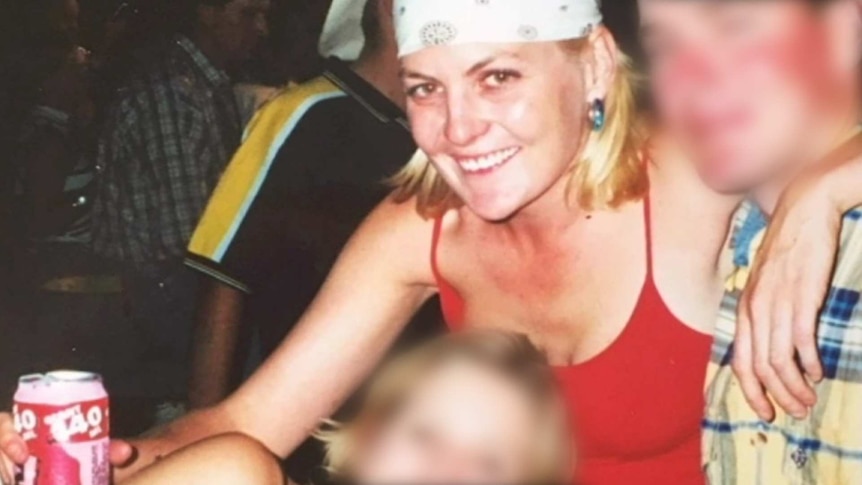 A photograph of a woman in a bandana and red singlet holding a can of drink