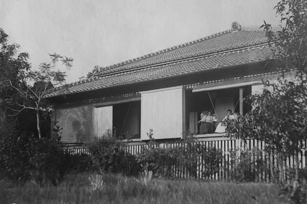 A black and white photograph of a single-storey house with a traditional Japanese roof