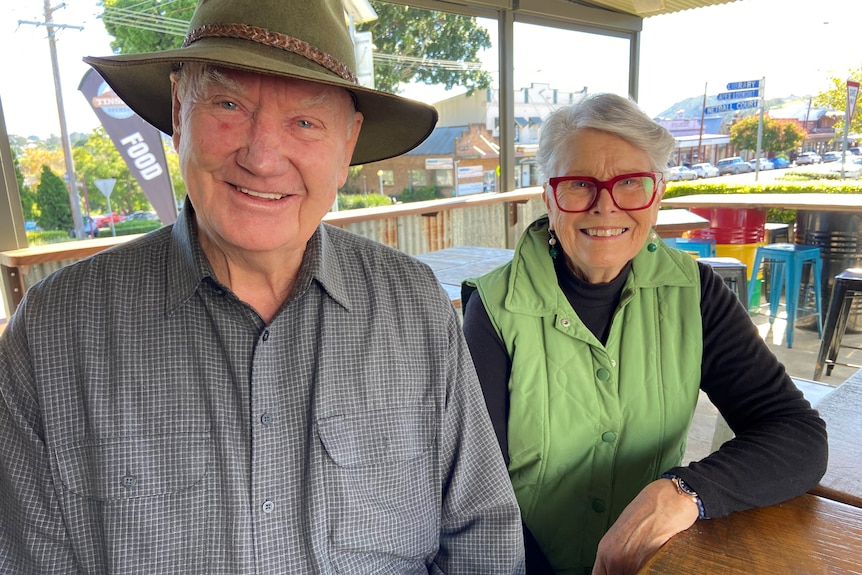 Older, smiling man and woman couple sitting at a table in the beer garden of Tinshed Brewery Dungog
