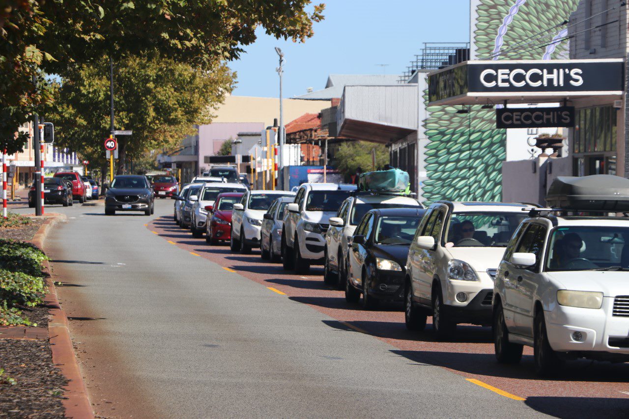 A queue of cars on a sunny street