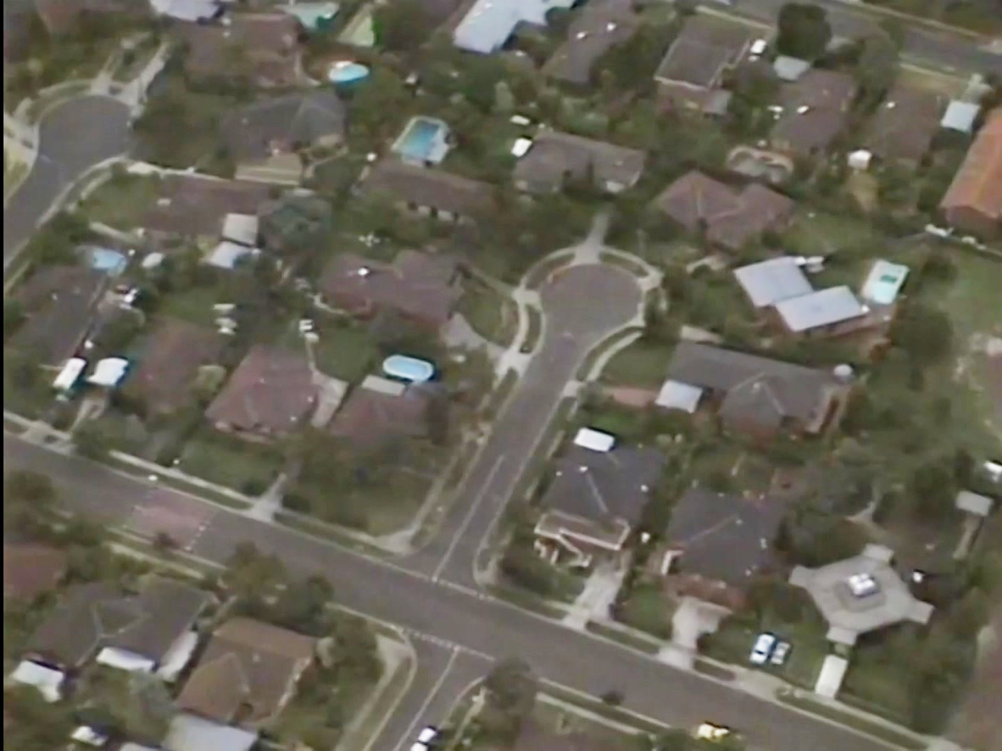 An aerial shot of a suburban street from the 80s.