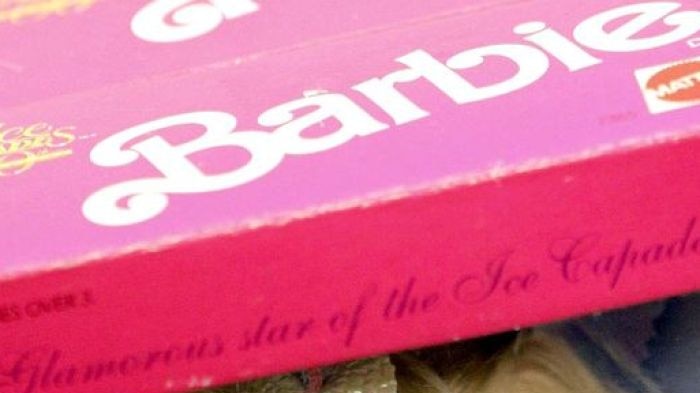 A barbie doll sits in her box