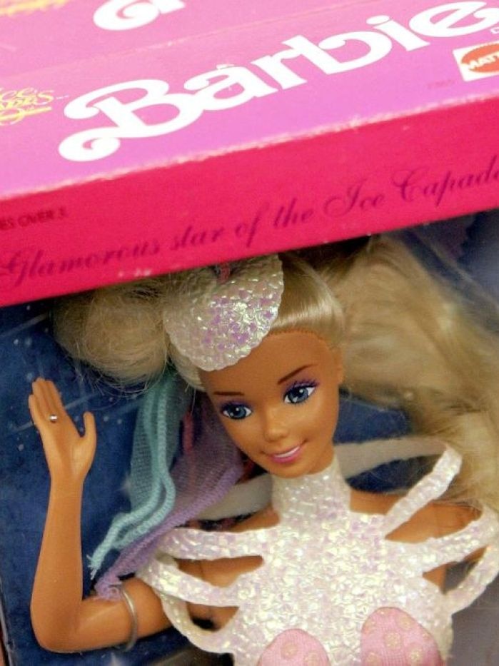 A barbie doll sits in her box