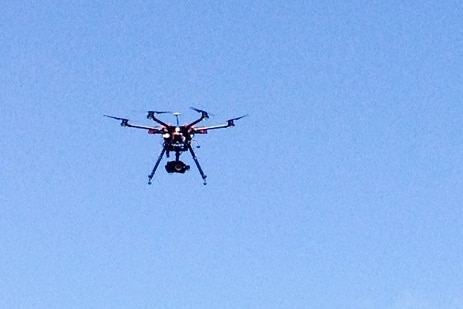 A multi-copter drone landed in a paddock.