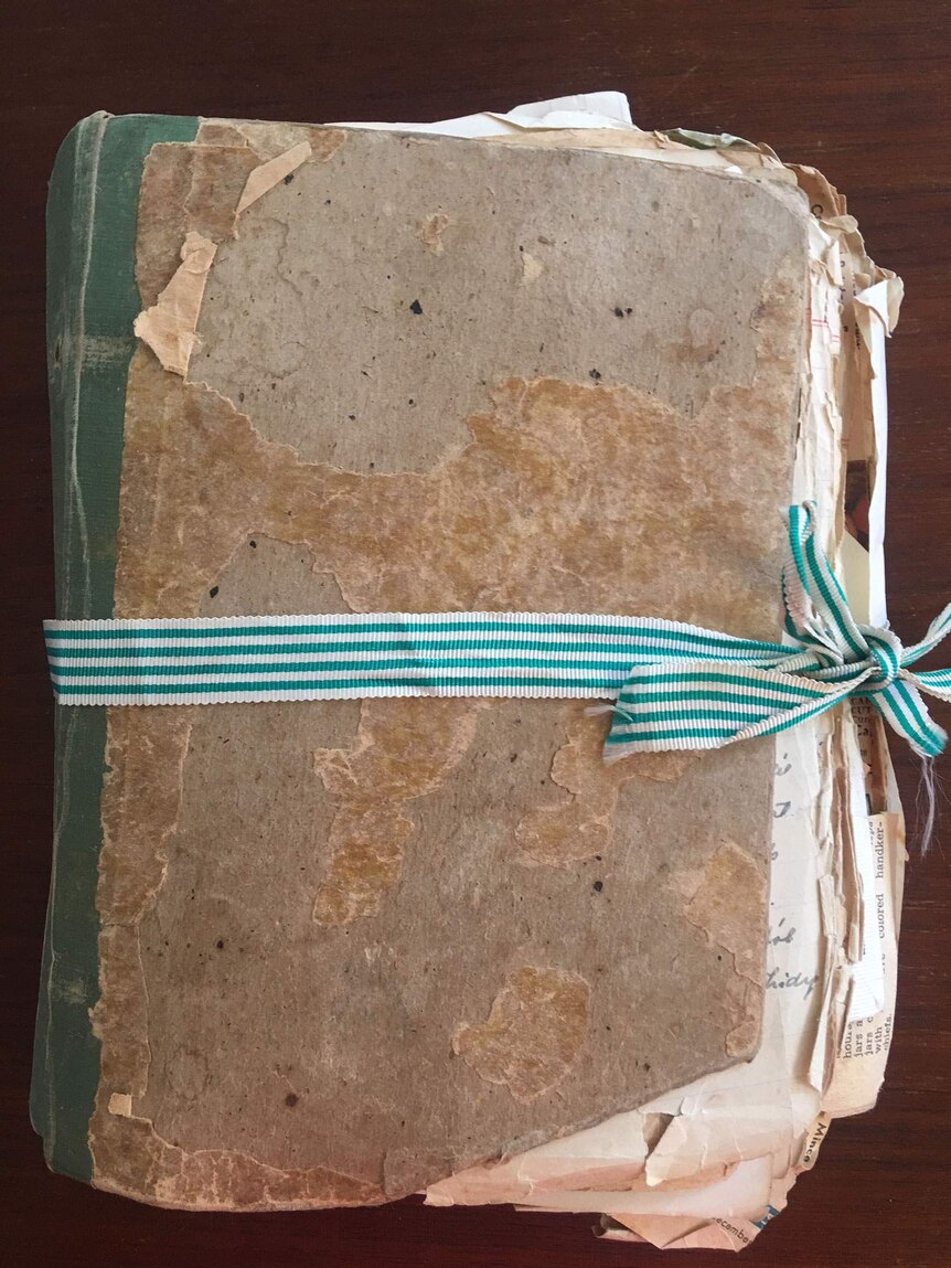 A tattered book tied together with a blue-and-white bow.
