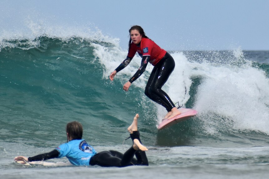 a young woman surfing.