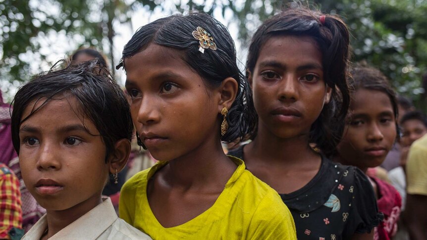 3 children waiting in line to get the relief from the Bangladesh Red Crescent Society.